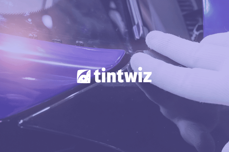 Vehicle wrap technician applying film with precision, supported by Tint Wiz