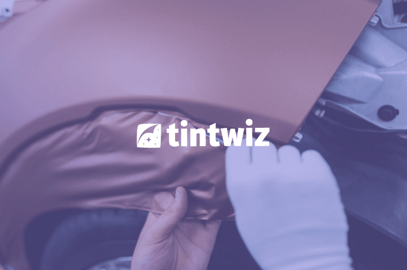 Installer in the process of vehicle wrapping, streamlined by Tint Wiz CRM